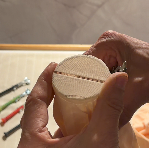 Place the fabric over a cylindrical object (such as a glass). Ensuring it is tight like a drum.